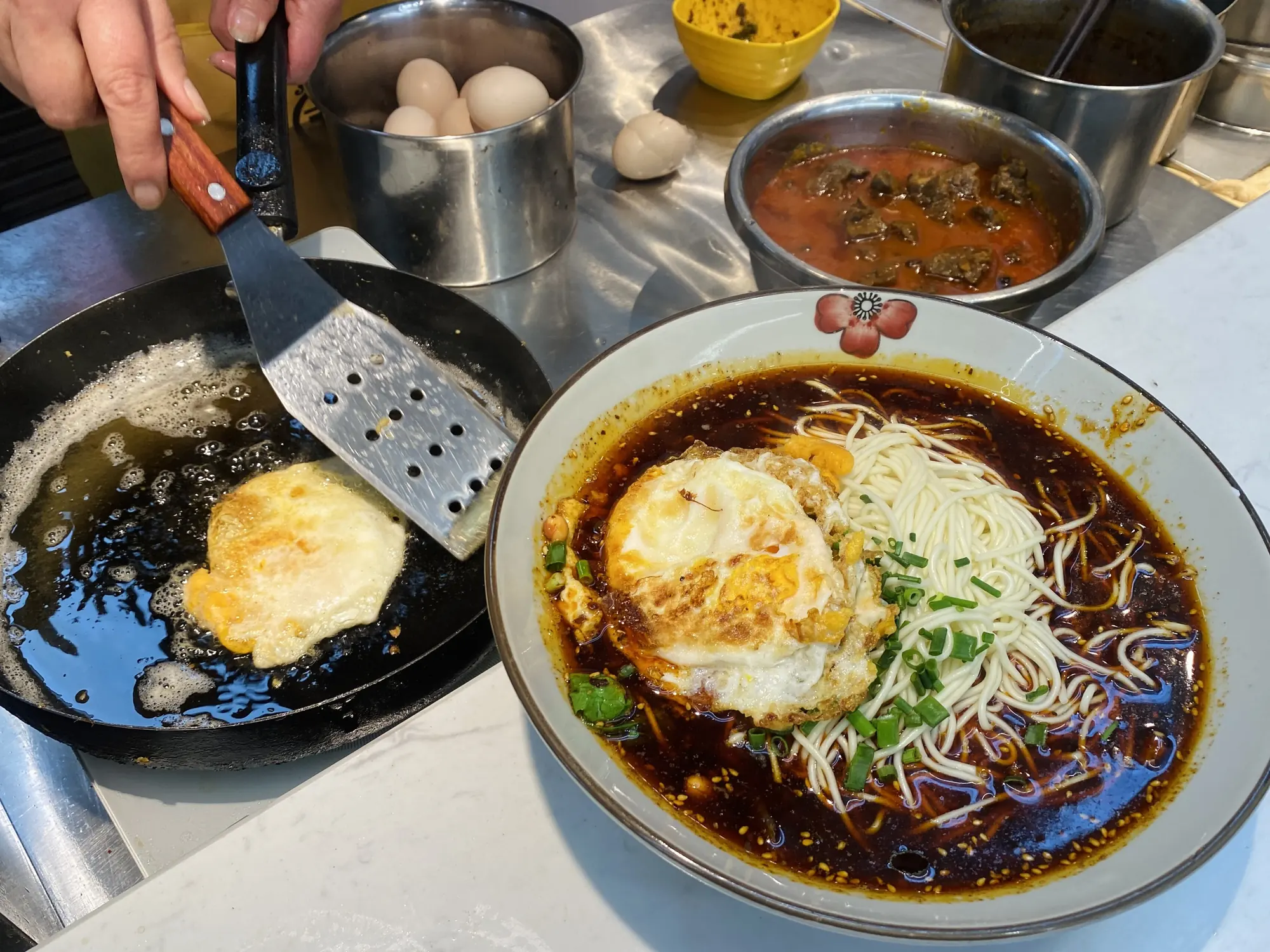 重庆小面馆灶台上翻滚的热汤与调料碗